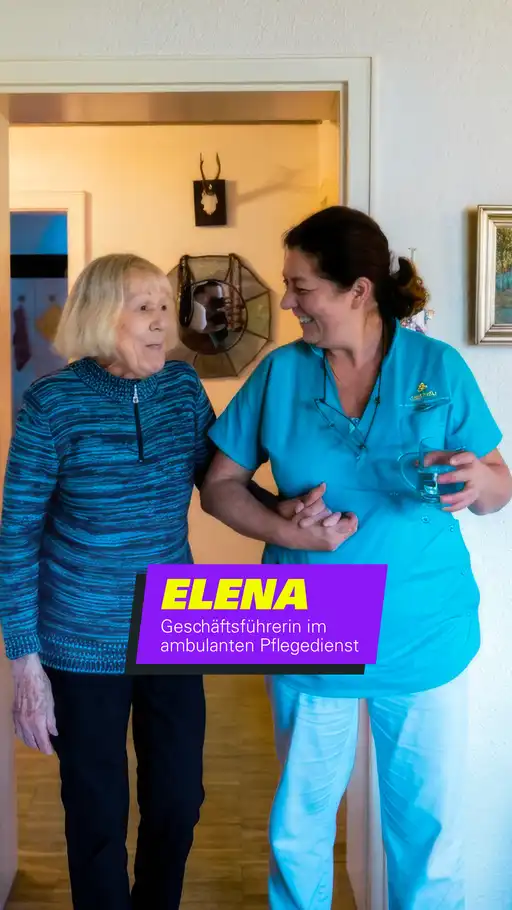 Quereinsteigerin Elena geht mit einer Patientin den Flur entlang