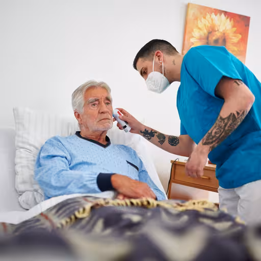 Ein Pfleger kümmert sich um einen Patienten