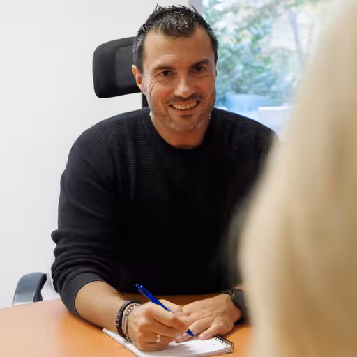 Pfleger im Gespräch am Schreibtisch