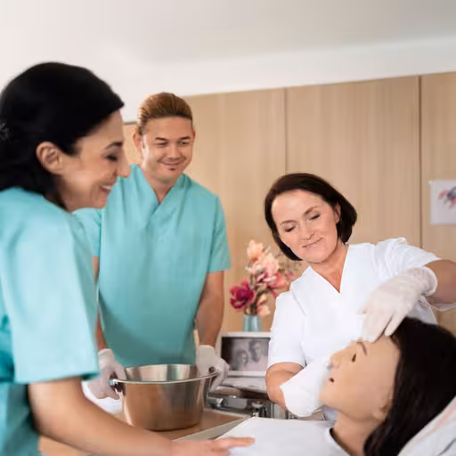 Eine Pflegerin zeigt etwas an einem Dummy